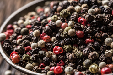 Mixed peppercorns red black and white in bowl - Close-up