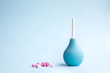 Fototapeten Blue douche and tablets of pink and white color on a blue background. Medical concept. © amtiko