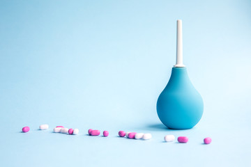 Blue douche and tablets of pink and white in bulk on a blue background.