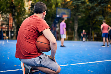 Man holding basketball ball on the urban city court.