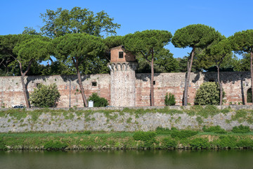 Fototapeta na wymiar Tower and wall of the Cittadella Nuova (New Citadel), now called Giardino Scotto (Scotto's Garden) an old fortress in Pisa at the river Arno, Italy