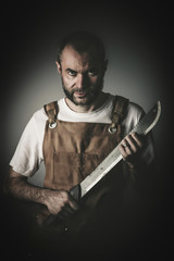 dramatic portrait of a killer holding a machete
