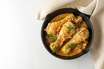 Spicy chicken in a sauce in a frying pan. top view from above