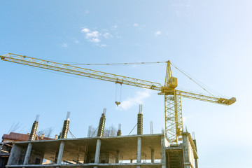 Tower crane on the blue sky background. Building construction work concept, investments in the development construction buildings and structures industry.