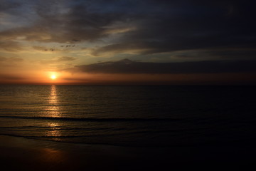 Fototapeta na wymiar Sonnenaufgang nach einer Regennacht am Meer - Wolkenstimmung am frühen Morgen