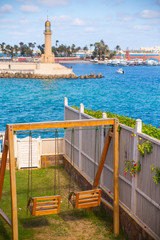 swing in a garden facing the sea and Alexandria lighthouse 