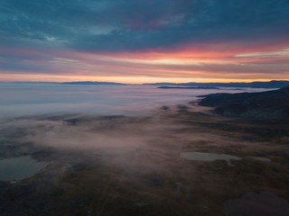 Misty morning in Greenland. Colorful landscape winh lakes, mountains and fog. Aerianl drone view.