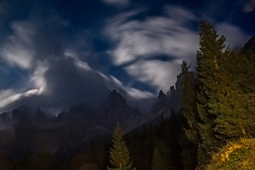 Night view with the moonlight among the clouds on the peaks of the Friulian Dolomites, near the Rifugio Giaff, in Friuli, Italy.