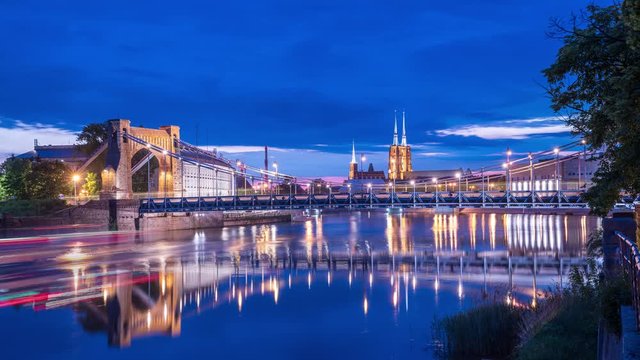Evening timelapse of river Odra in Wroclaw, Poland. Grunwaldzki Bridge in the background with other landmarks. Calm summer night.