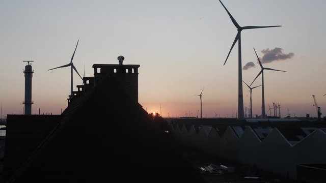Cinematic slow motion shot of windturbines in the background during sunset