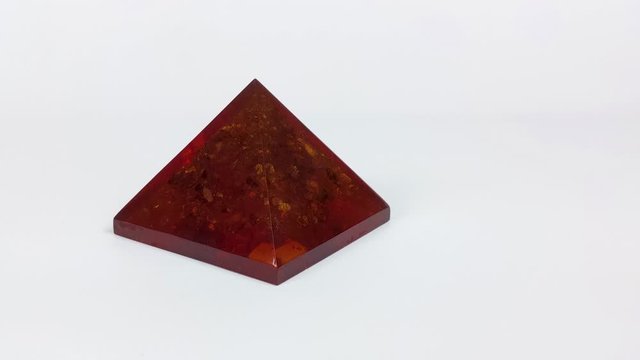 Dolly shot of the slowly rotating Orgone Pyramid in 4K on the white background. Repels negative energy and EMF waves.