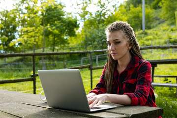 Young woman working outdoors on her laptop