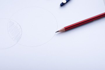 Intersecting circles with pencil and compass on white paper