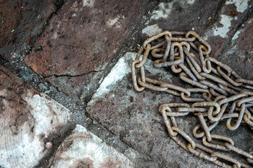 Rusty chain on the brickwork. The symbol of slave labor