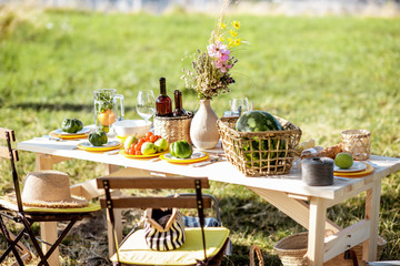 Beautifully decorated lunch table with food, drinks and flowers in the garden