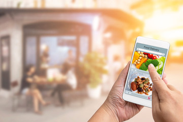 Online order Food shopping concept on touch screen on woman hand. Food delivery service express that is cooked by restaurant and icon symbol media. Business and technology with lifestyle in city.
