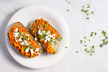 Bread toasts with paprika paste, feta cheese and arugula sprouts, healthy snack