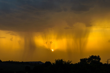 tormenta de verano con el sol tiñendo el cielo de amarillo