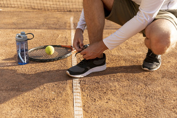 Tennis player tying his shoes