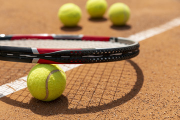 Close-up tennis racket over ball