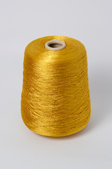 Green bobbin of yarn on a white background.Textile reel on isolated white background.