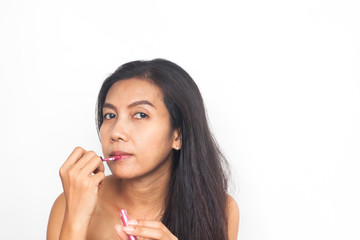 Portrait of 40s Asian woman applying lips gloss on her lips. Healthy and Beauty concept. Anti aging and surgery.