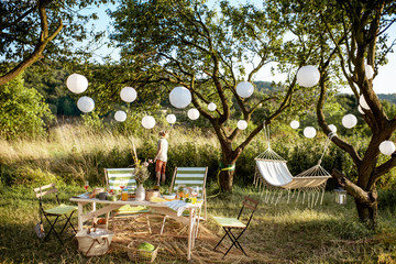 Beautifully decorated yard with sunbeds, table, hammock and decorative lanterns, ready for the...