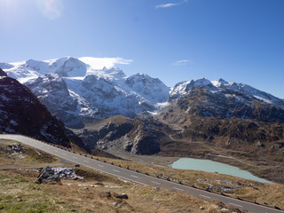 Road down form the Susstenpass, Switzerland with snowy peaks and empty road.