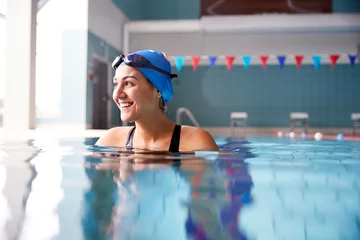 Foto op Plexiglas Female Swimmer Wearing Hat And Goggles Training In Swimming Pool © Monkey Business