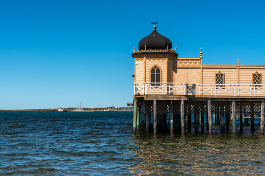 Summer seaview of the famous old historic wooden bathhous Varbergs Kallbadhus. A cold water public bath located in the ocean with a bridge ashore in Sweden.