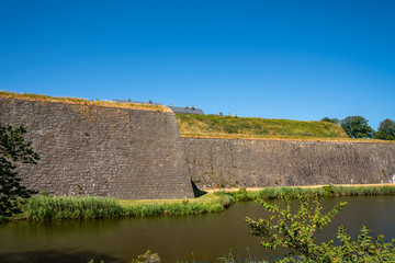 Beautiful summer landscape with a historic and old massive medieval defense wall at Varbergs Fortress in Sweden. Blue sky and water.