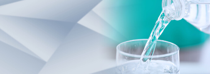 Pouring water into a glass; panoramic banner