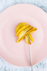 French fries. Homemade, roasted french-fried potatoes. Top above view on table. Junk food. On plate with fork.