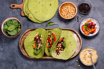Vegan green tortilla flatbreads or tacos for healthy snack with cheakpeas, hummus, grilled...