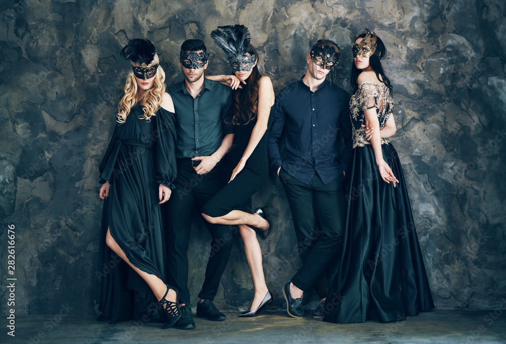 Wall mural Group of people in masquerade carnival mask posing in studio - Wall murals