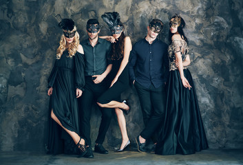 Group of people in masquerade carnival mask posing in studio