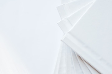 Closeup stack of white books in geometric placement on white background. White abstract background. Copy space