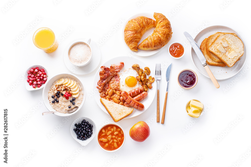 Wall mural top view flatlay with varieties of fresh breakfast: fried eggs with bacon and sausages, oatmeal with