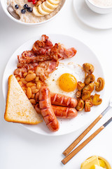 Classical english breakfast with fried bacon, mushrooms and eggs. Flatlay on white background