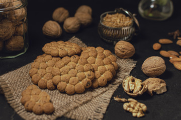 Biscuits and nuts on black surface