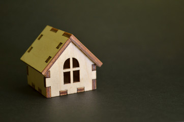 Wooden toy house model on a black background with copyspace