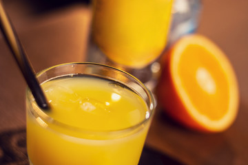glass with fresh orange juice on wooden table close up