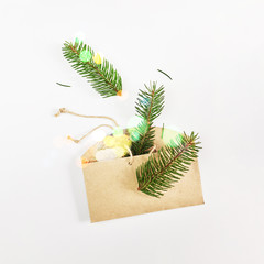 Christmas and New Year card. Fir branches in cardboard handmade envelope over white background