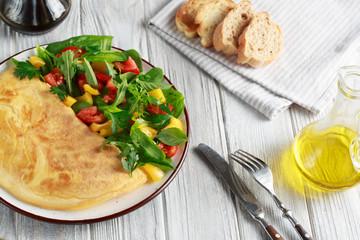 Omelet with cheese coupled with rucola, spinach, tomato, paprika and seasoning. Continental breakfast or English breakfast.