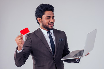 indian business man with credit card holding modern laptop at studio white background,black friday sales