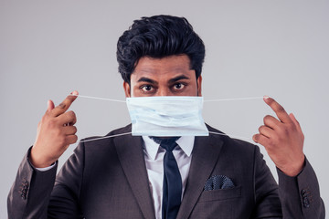 young indian business man protect his healthy with medical mask at work in studio on white background