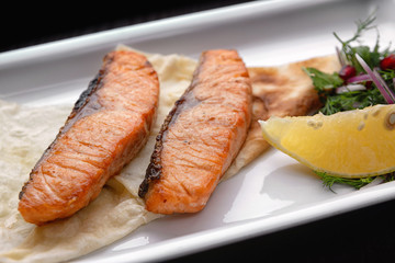 Fried salmon on a white plate 2 pieces