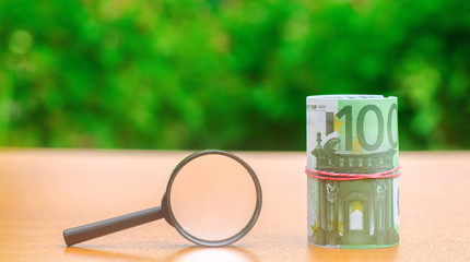 Euro banknotes and magnifying glass. The concept of finding sources of investment and sponsors. Find a money. Charitable funds. Startups and crowdfunding. Search for cheap loans