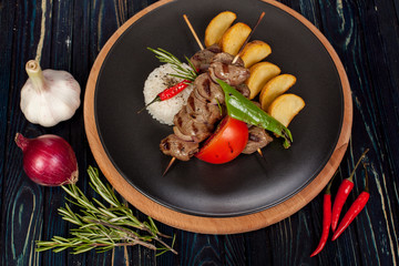 juicy, fried, tender steak with vegetables and sauces on a special stand