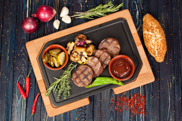 juicy, fried, tender steak with vegetables and sauces on a special stand
